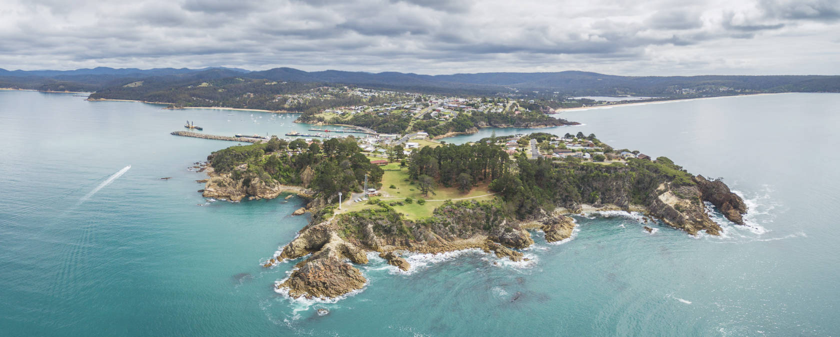 A lush green landform surrounded by ocean