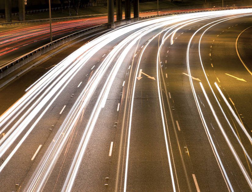 Car headlights through a night-time freeway