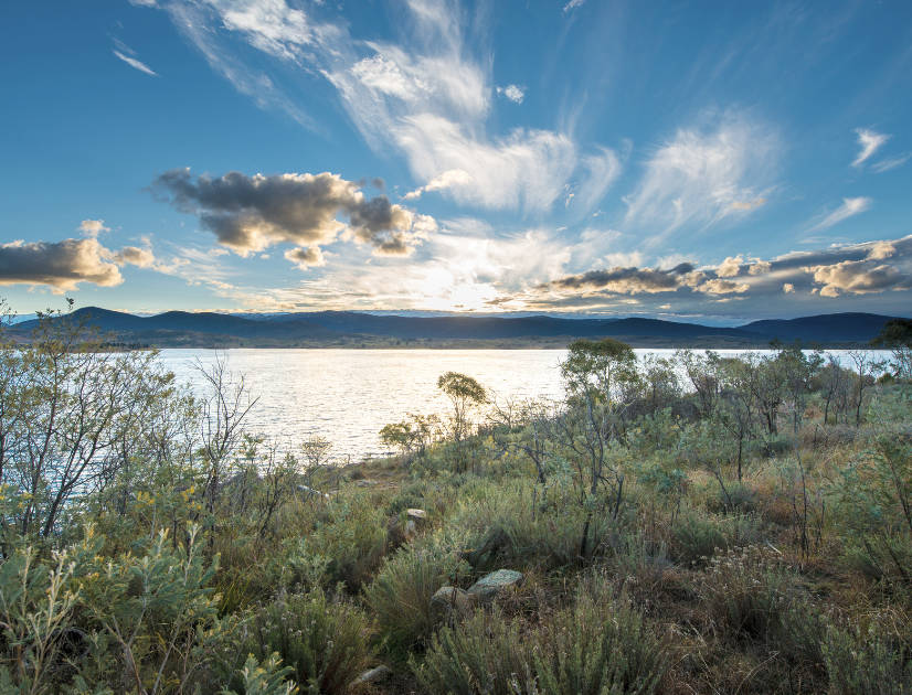 A lake surrounded by mountains under a blue sky