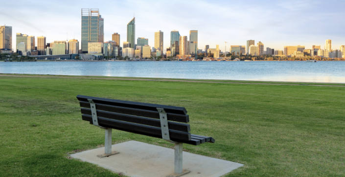 A park bench looking out at the river and Perth city horizon