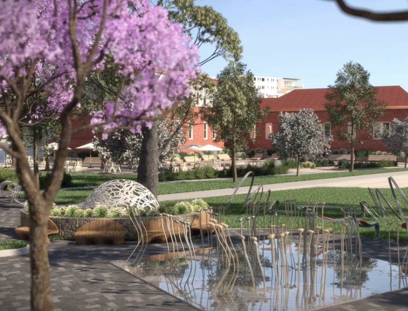 Tree with pink foliage overlooks a sculpture-decorated pond